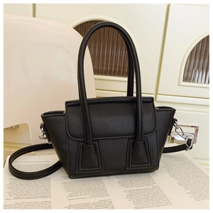 Detail of black litchi grain leather bag with silver hardware and adjustable strap