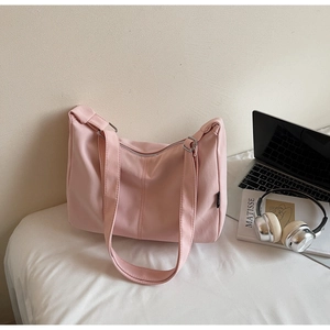Detail of soft pink nylon shoulder bag with adjustable strap and metal hardware