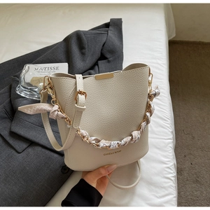 Detail of off-white bucket bag with lychee grain leather and floral scarf chain handle