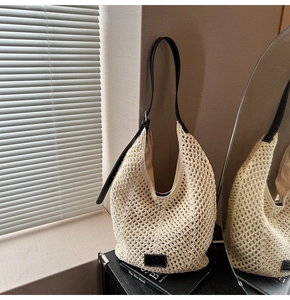Detail of hollow woven beige hobo bag with adjustable black leather shoulder strap