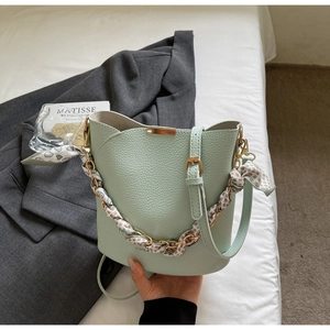 Détail du sac seau vert menthe avec texture lychee et foulard en soie à cœurs