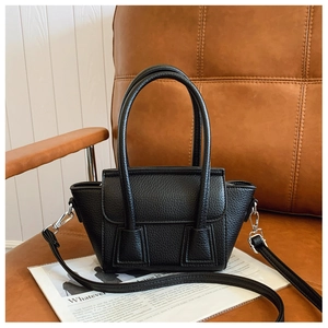 Detail view of black litchi pattern bucket bag with detachable straps and silver hardware
