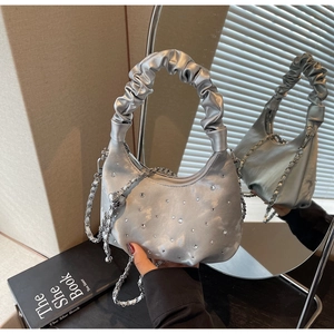 Detail of silver pleated cloud bag with sparkling rhinestones and metal chain strap