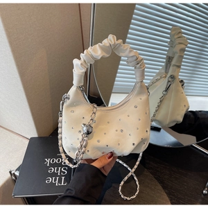 Close-up of a white hobo bag with rhinestone details and a trendy scrunchie handle