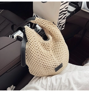 Detailed view of the hollow crochet weave texture and black leather shoulder strap detail