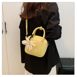 Detail of yellow lychee pattern boston bag featuring a floral charm and fashion embossing