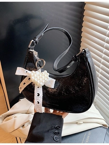 Glossy black half-moon shoulder bag with pearl heart charm and lace bow detail