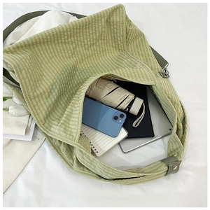 Top view of spacious green checkered canvas tote bag filled with daily laptop essentials