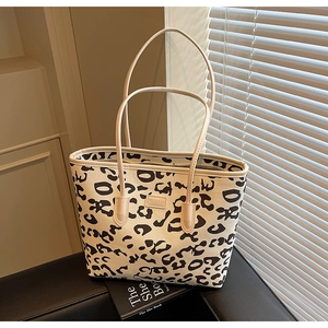 Detail of MEIGEBAG tote with leopard print pattern and brand logo on a stylish stand
