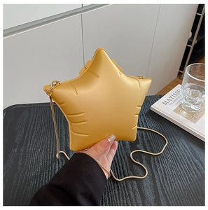 Detail of star-shaped crossbody bag in bright yellow with puffy embossed texture and gold chain