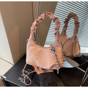 Close-up of pink pleated dumpling bag with rhinestones and silver chain strap
