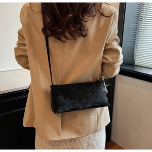 Detailed view of a vintage black shoulder bag with matte texture on a model