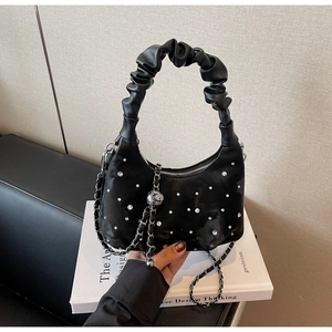 Detailed macro view of black satin hobo bag featuring sparkling rhinestones and chain strap