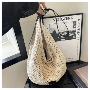 Detail of hand-woven crochet hobo bag with large hollow knit and black leather strap