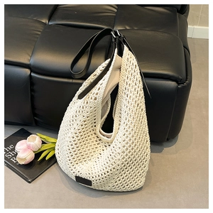 Detail of crochet tote bag featuring mesh texture and black leather strap for beach travel