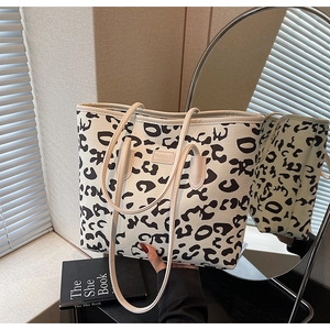 Close-up of leopard print tote bag featuring a minimalist brand label and canvas texture