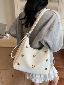 Off-white crossbody bag with silver butterfly charms and crinkle texture shown on model