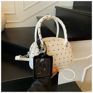 Detail of white heart-print bowling bag with dual handles and hanging card holder
