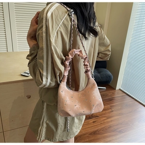 Detail of pink rhinestone crossbody bag with chain strap and crystal pleated handle
