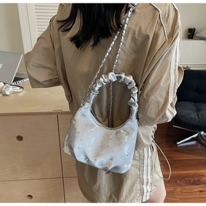 Silver satin hobo bag with sparkling rhinestones and a scrunchie handle in detail view
