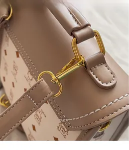 Detail of golden metal hooks and lychee pattern leather on a khaki designer handbag