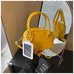 Detail view of yellow glossy bowling bag with white heart patterns and ID card holder
