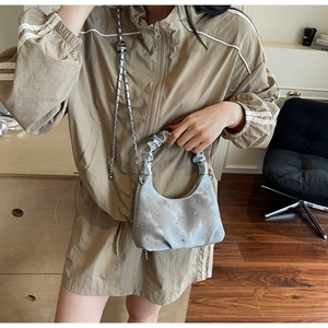 Detailed close-up of a silver rhinestone pleated hobo bag with a cloud handle and chain