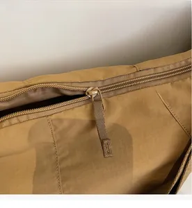 Macro detail of the smooth metal zipper and khaki ripstop fabric on this tote bag