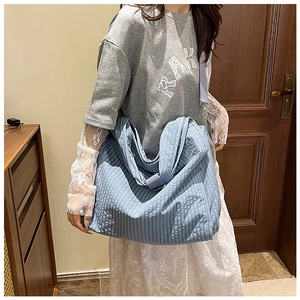 Detailed texture of light blue canvas tote bag with vertical stripes and wide strap