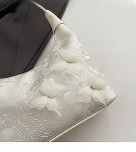 Close-up of white jacquard fabric featuring 3D tulle butterfly appliques and rhinestones