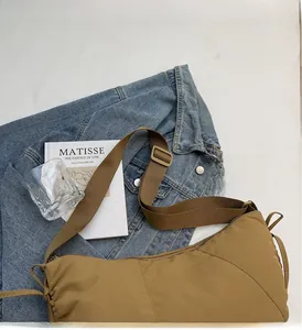 Detail of khaki nylon dumpling bag with adjustable shoulder strap on lifestyle background