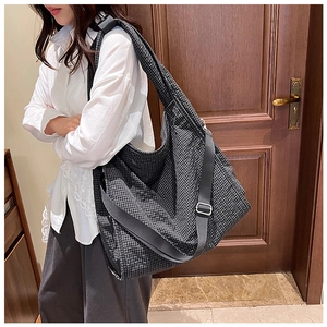 Detailed view of black and white checkered canvas tote bag with adjustable shoulder strap