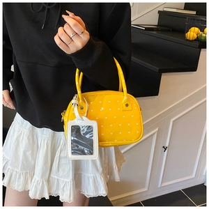 Close-up of yellow bowling bag with white heart patterns and functional card holder
