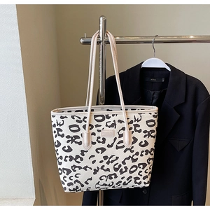 Detailed view of large leopard print tote bag with shoulder straps and brand embossing