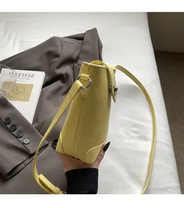 Detail of bright yellow pebble leather bucket bag with premium silver hardware accents