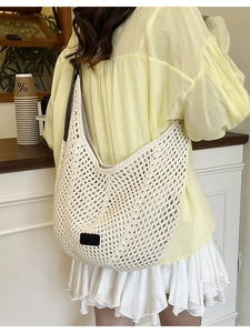 Handcrafted cream crochet tote bag with black straps and square leather patch detail