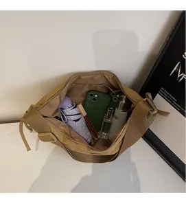 Internal view of khaki nylon crossbody bag showing large storage capacity with daily items