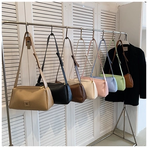 Detailed display of pleated shoulder bags in eight trendy colors hanging on hooks