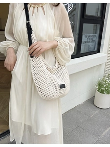 Chic cream knit hobo tote bag with black adjustable strap and gold chain detailing