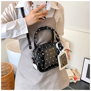 Detail of black patent leather bowling bag with white heart prints and adjustable strap