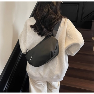 Rückansicht minimalistische schwarze Brusttasche mit silbernem Dekor am Gurt