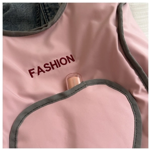 Detail of pink vintage backpack showing heart-shaped pocket with FASHION embroidery