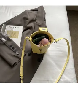 Top-down detail of yellow leather bucket bag showing large interior space and silver clasp