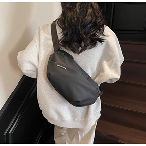 Detailansicht der schwarzen Nylon-Halbmondtasche mit verstellbarem Gurt am Model
