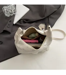 Detailed interior of a white lace handbag showing pockets and storage space