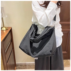 Detail of large black and white checkered canvas tote bag with adjustable shoulder strap