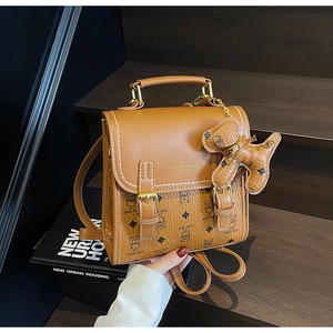 Detailed view of brown vintage backpack featuring bear patterns and metal buckles