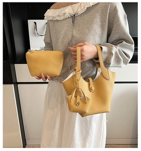 Detailed view of yellow lychee grain leather bucket bag set with matching inner pouches