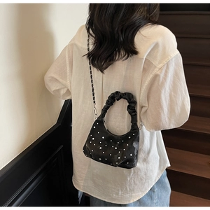Detailed back view of a black pleated dumpling bag with rhinestones and chain strap