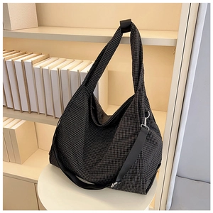 Detail of checkered canvas tote bag with adjustable shoulder strap and metal hardware